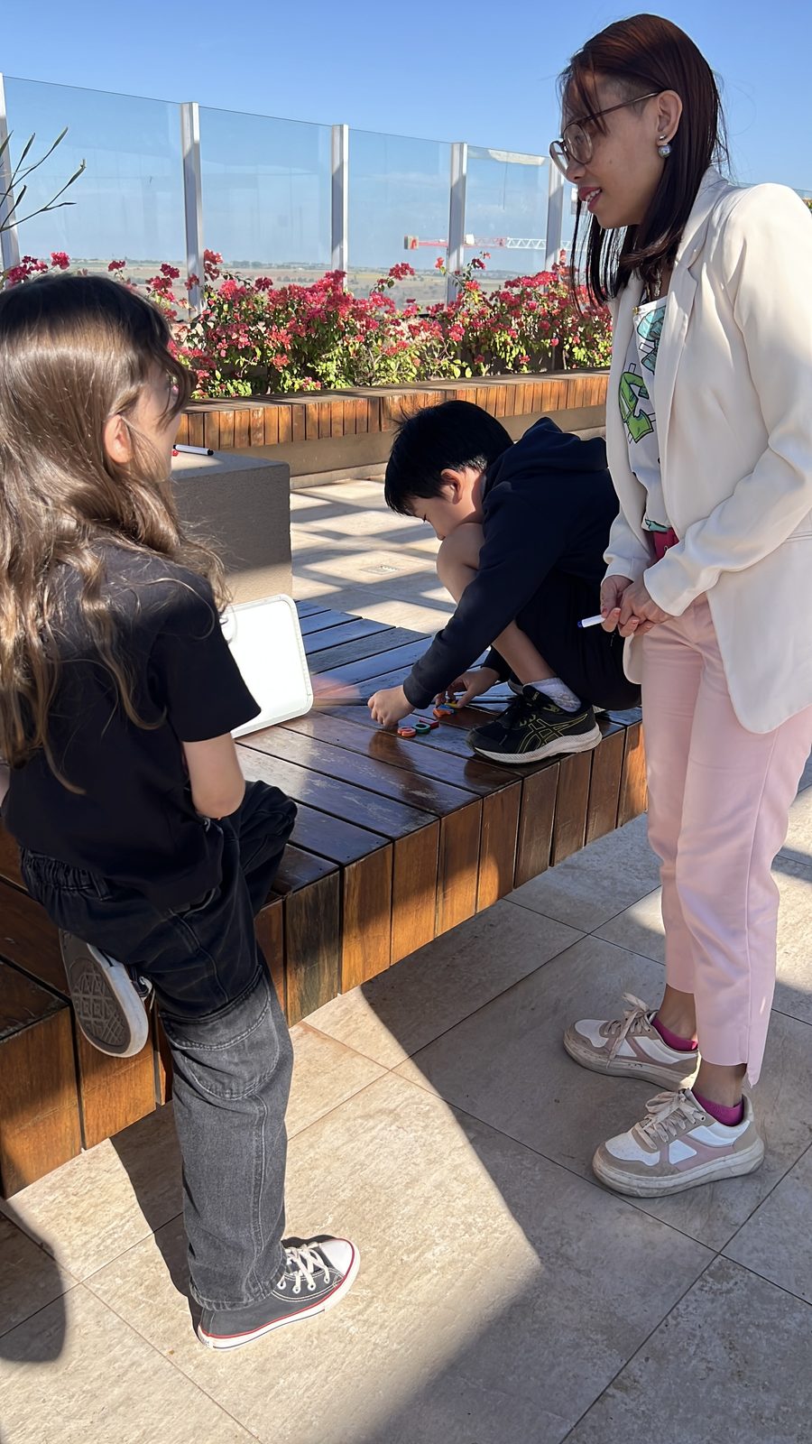 Professora brincando com alunos em atividade ao ar livre na AnyKids.
